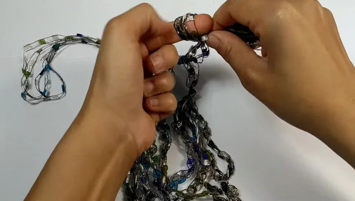 Tie a knot at the very end of each tail to secure the necklace and prevent sliding.