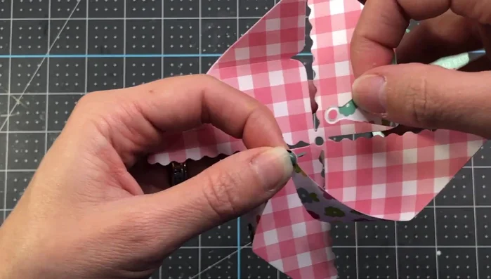 Push the brad through the center hole and secure it.