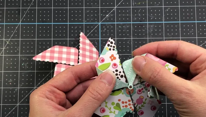 Attach the smaller pinwheel to the flat side of the larger pinwheel, securing the brad through the center.