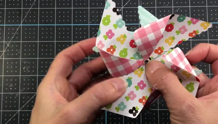 Attach the smaller pinwheel to the flat side of the larger pinwheel, securing the brad through the center.