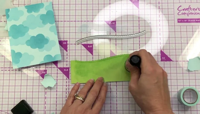 Die cut a scalloped border from green cardstock and add ink for dimension.