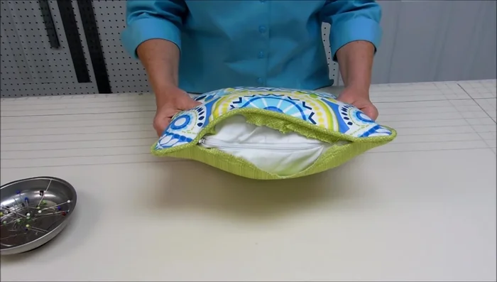 Hand sew the opening closed: Fold the bottom edge of the back fabric under, align it with the cording, and hand-stitch the opening closed.