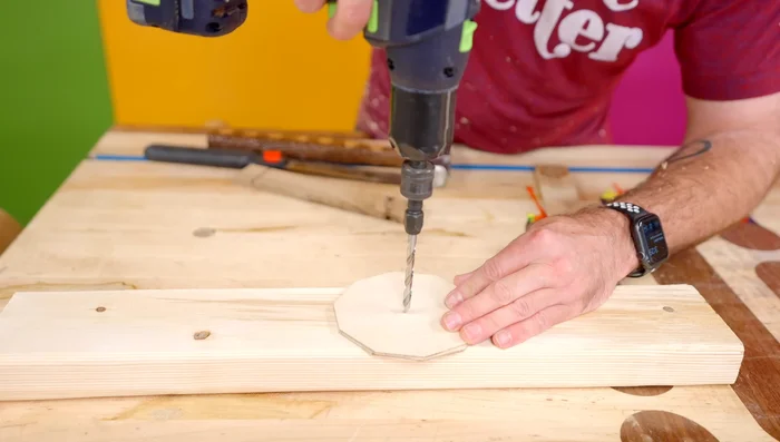Drill a drainage hole in the plywood base. Add glue to the base and insert into the holder.