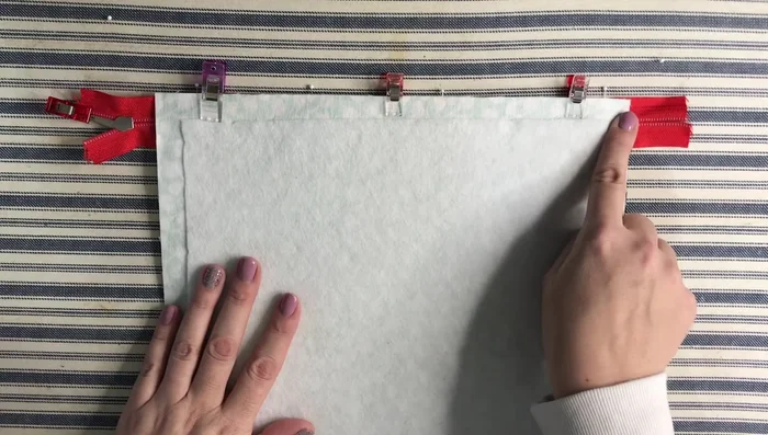 Sew along the top edge, securing the zipper to both the outside and lining.