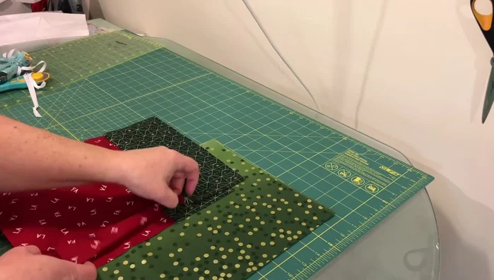 Sew main fabric: Sew the side and bottom seams of the main fabric pieces with a 1/4" seam allowance. Square off the corners by opening them up, aligning seams in opposite directions, and sewing across the corner.